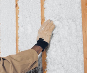 Worker assessing JM Spider installed in wall cavity.