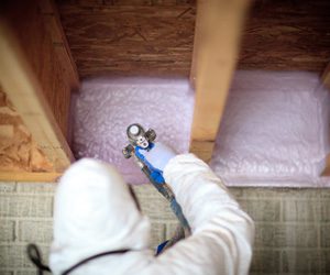 Worker spraying insulation foam