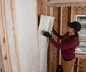 white fiberglass batt insulation installed in a wall cavity