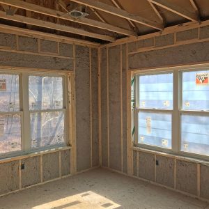 Wet cellulose insulation installed in exterior walls with windows.