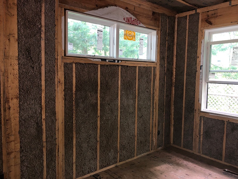 Wet cellulose insulation installed in exterior home walls with windows