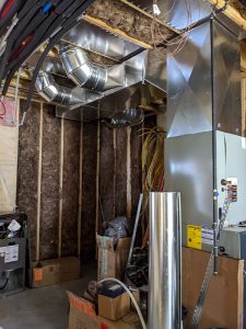 Fiberglass insulation in basement of custom home with new ductwork.