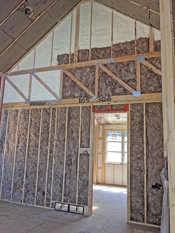Fiberglass and spray foam insulation in interior walls of custom home for soundproofing.
