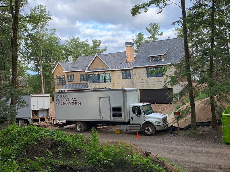 Whitson Insulation trucks outside of custom home build in Leland, MI