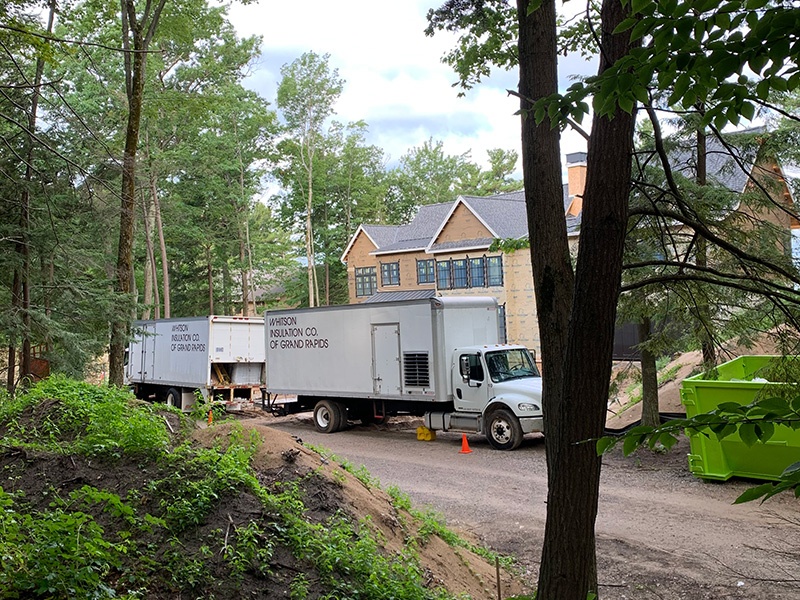 Whitson Insulation trucks parked outside of new residential construction