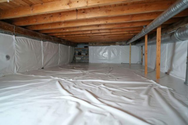 A clean, well-sealed, and insulated crawl space with a white vapor barrier covering the floor and walls.