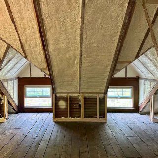 Cathedral ceiling attic with closed-cell spray foam insulation between exposed rafters.