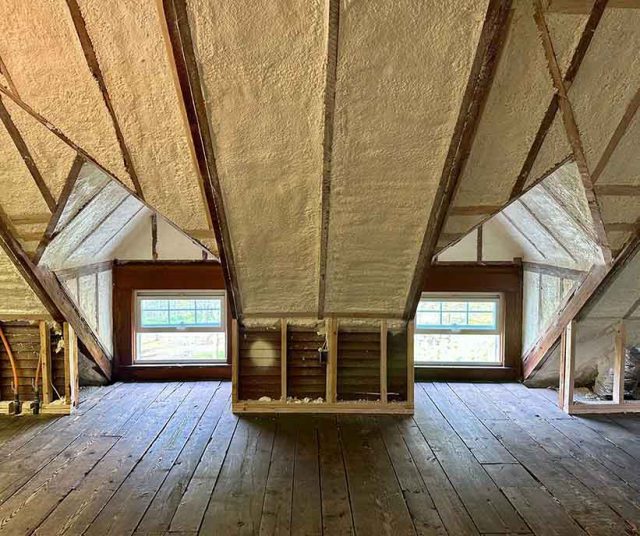 Cathedral ceiling attic with closed-cell spray foam insulation between exposed rafters.