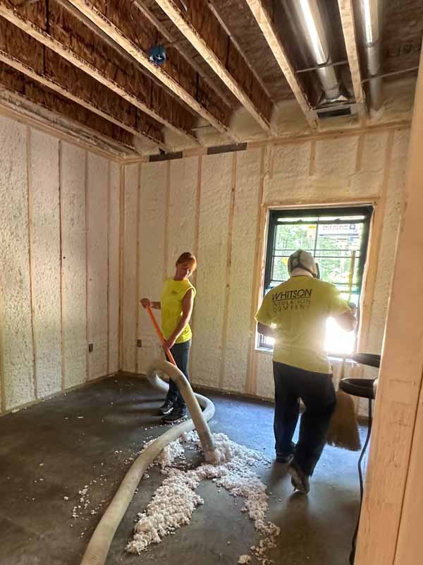 Hybrid insulation system: closed-cell spray-foam walls and R-49 fiberglass batts on a vaulted ceiling in the Baldwin, MI church-style addition.