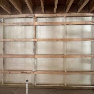Wide view of interior wall covered in closed-cell spray foam inside barndominium