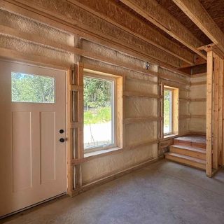 Entry door and windows insulated with closed-cell spray foam inside framed wall