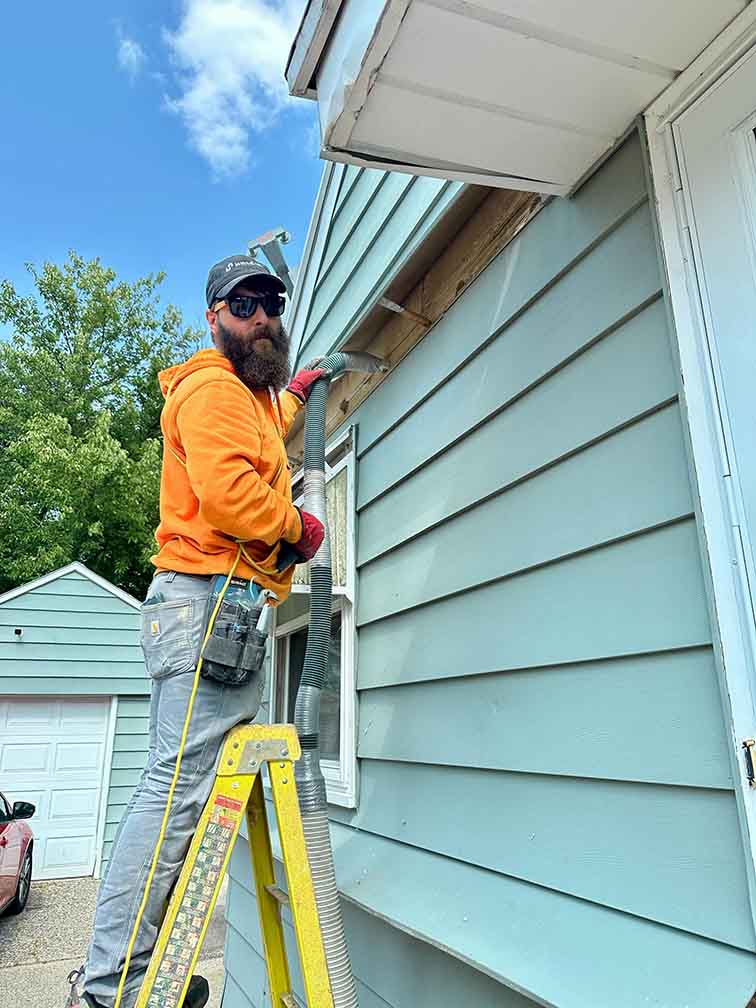 Blowing cellulose insulation into wall cavities for better energy efficiency and comfort.