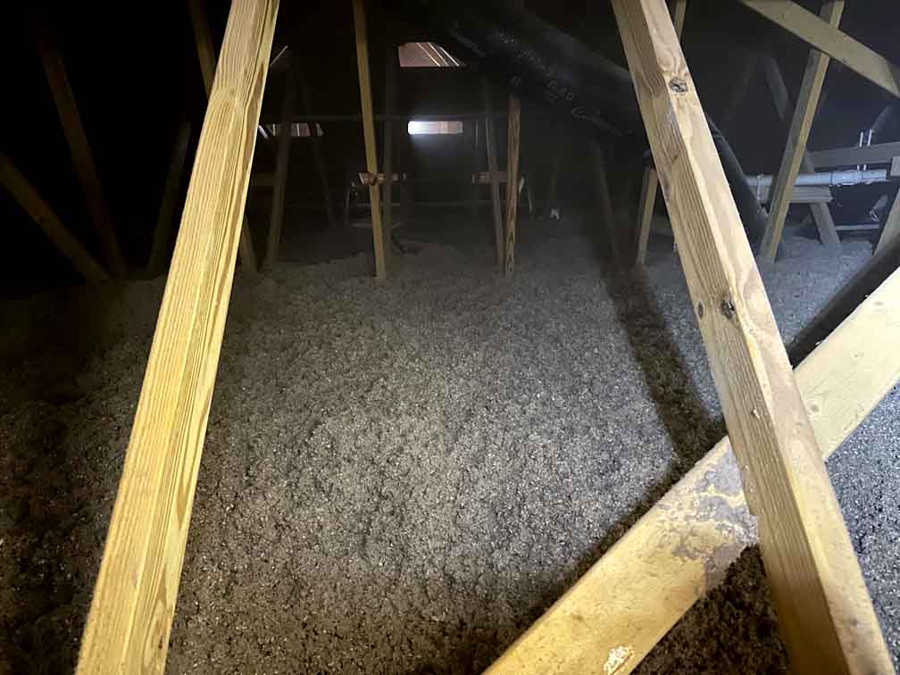 Blown-in cellulose insulation on attic floor. Blown-in cellulose insulation on attic floor.