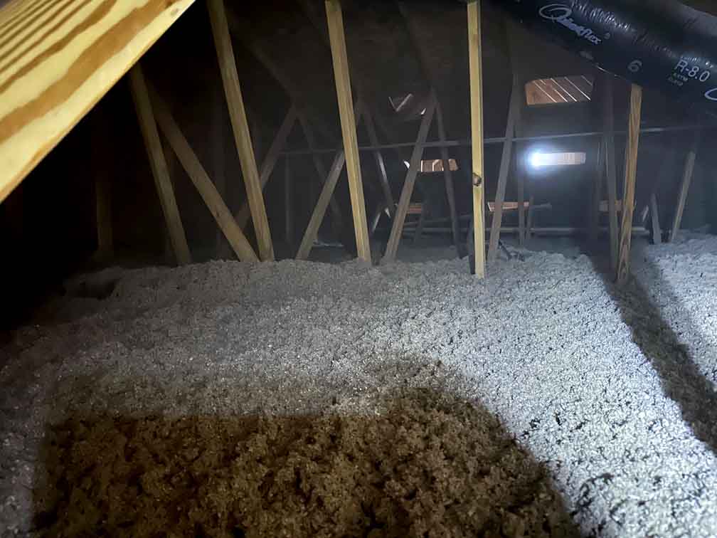 Blown-in cellulose across the attic floor. Blown-in cellulose across the attic floor.